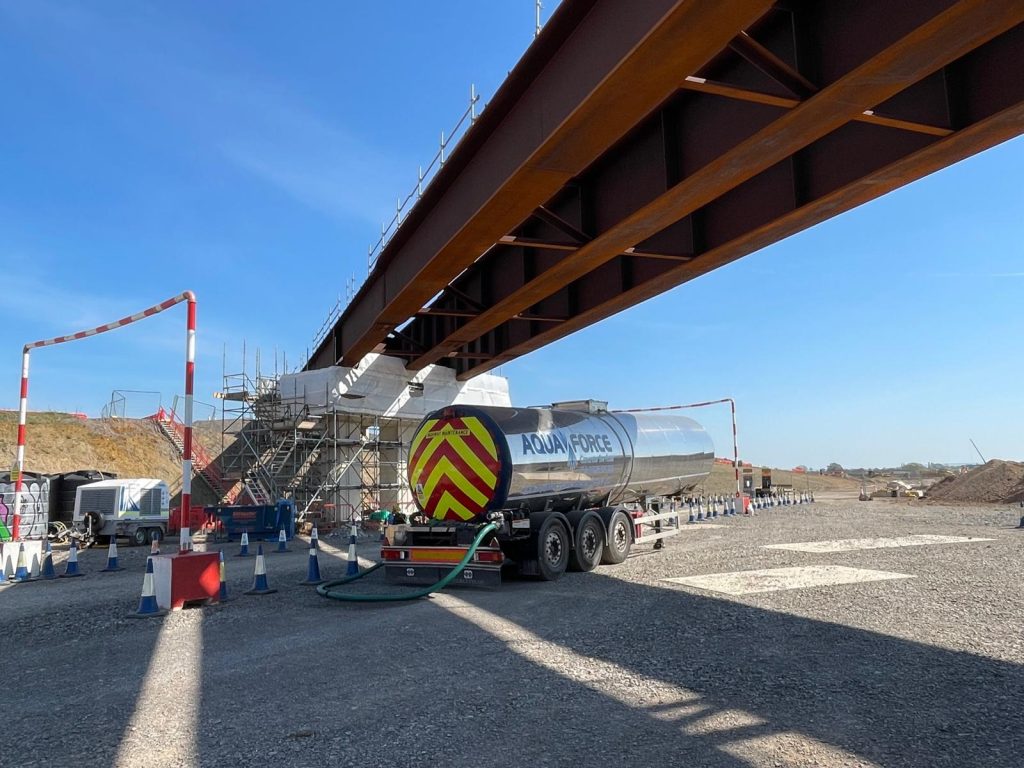 Aquaforce Concrete Services tanks in the sunshine under a bridge, carrying out hydrodemolition in the sunshine